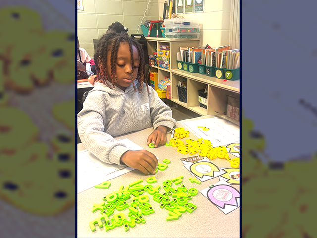 A student at Birmingham’s Hayes K–8 School constructs words using magnetic letters.