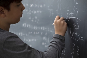 Student doing math on a chalkboard