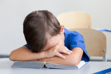 Upset child reading in a classroom