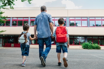 Parent and children walking to school