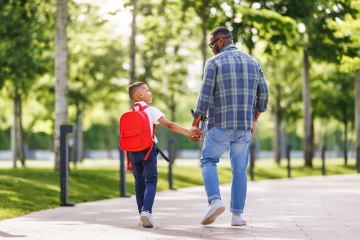 Father and son walking to school
