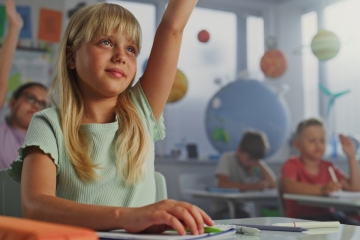 Student raising hand in classroom