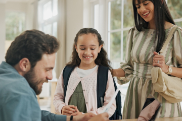 Parents and daughter looking at a report card