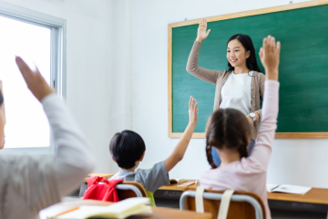 Teacher and students with hands raised