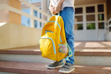 Student outside school with a backpack