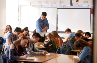 high school teacher inspecting class