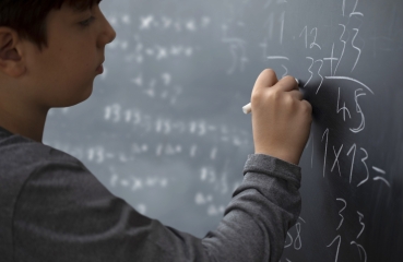 Student doing math on a chalkboard