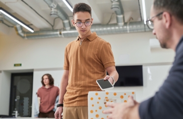 Student putting a cellphone in a box in a classroom