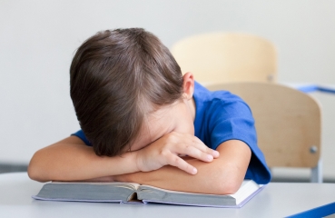 Upset child reading in a classroom