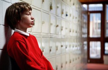 Upset teen boy in school hallway