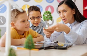 Science teacher and students working on a project