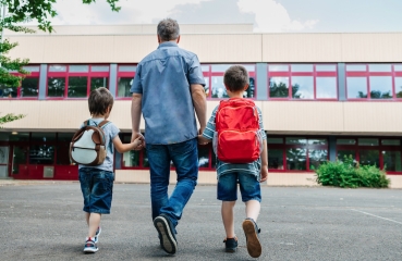 Parent and children walking to school