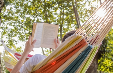 Person reading a book in a hammock 