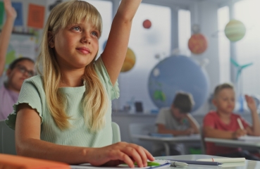 Student raising hand in classroom