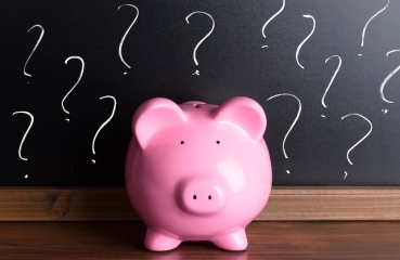 Piggy bank and chalkboard with question marks