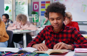 Student reading a book in class
