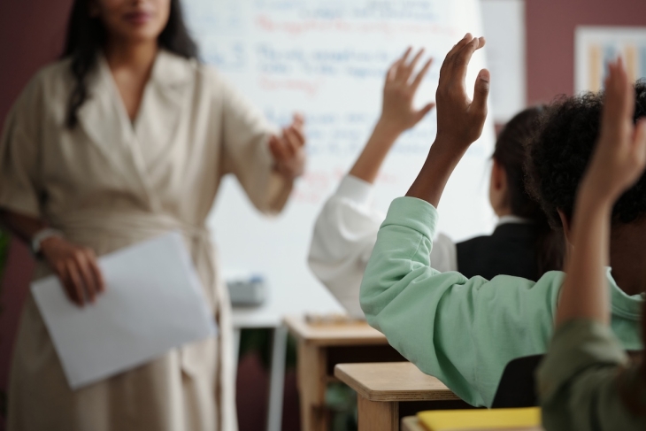 Students raising their hands in a school classroom