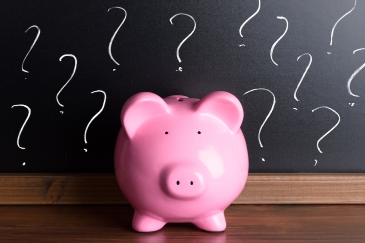Piggy bank and chalkboard with question marks