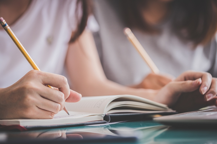 Students writing with pencil and paper
