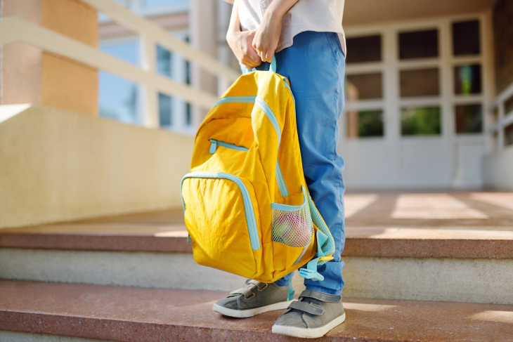 Student outside school with a backpack