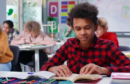Student reading a book in class